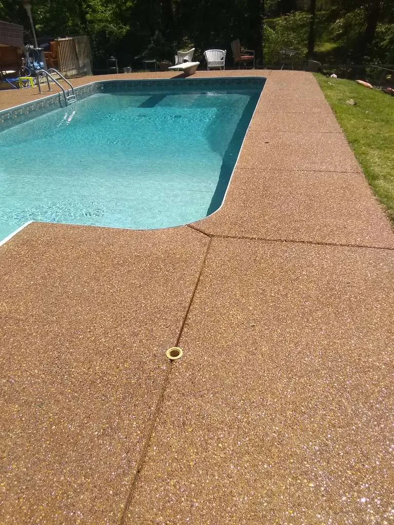 Exposed aggregate pool deck around a swimming pool
